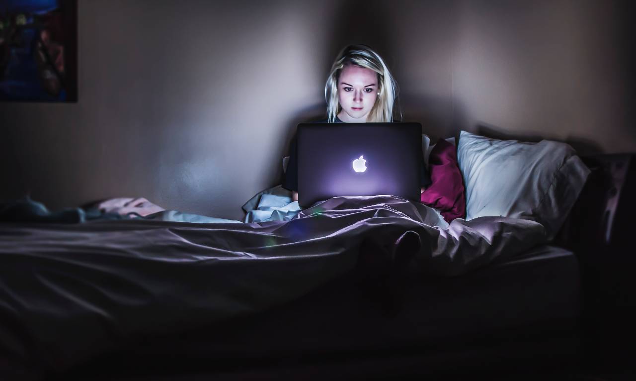 Women in bed looking at laptop