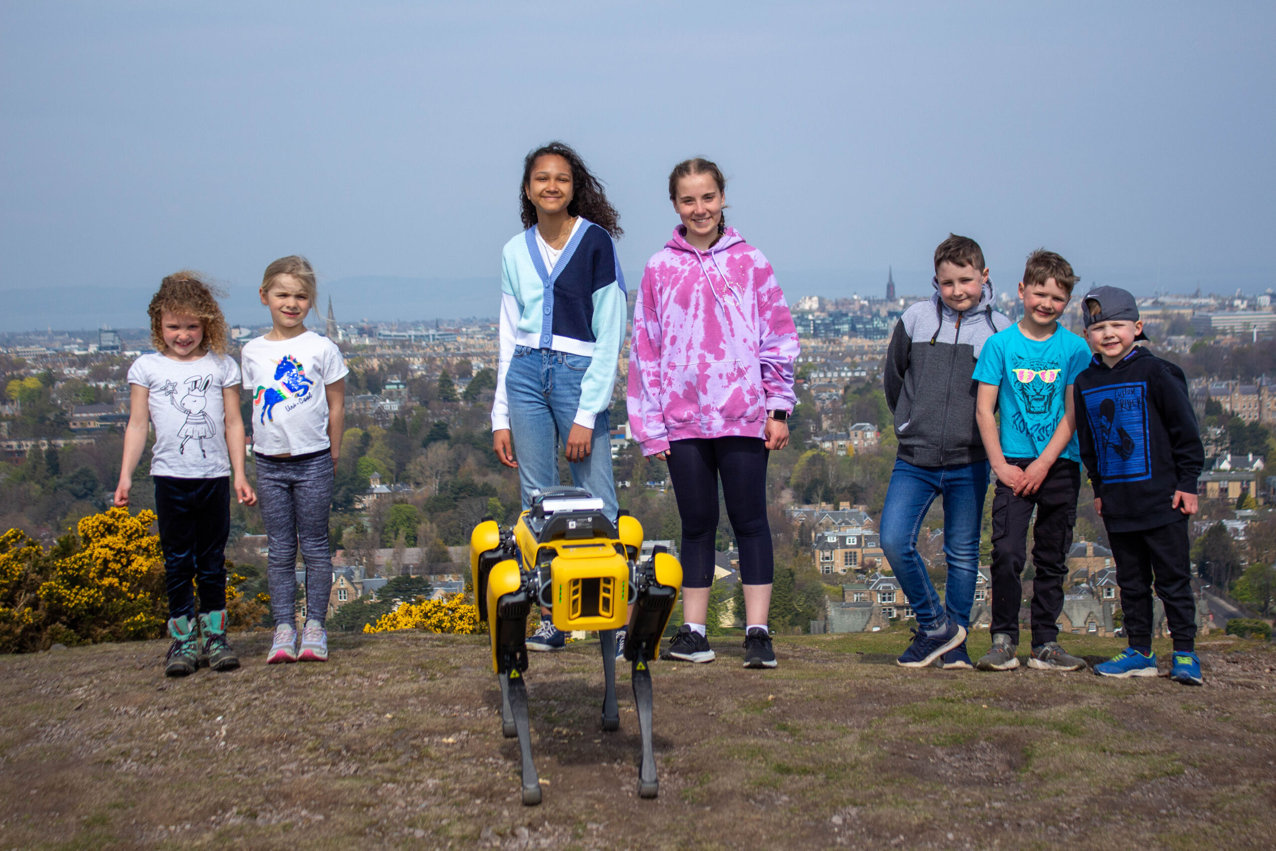 School pupils on a hill with robot dog