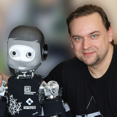 Dr. Ingo Keller, Head of Robotics at National Robotarium, standing with iCub robot