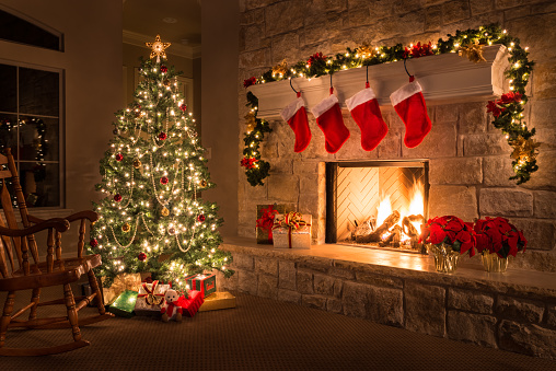 Stock image of christmas tree and stockings in front of fireplace